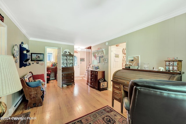 bedroom with a baseboard heating unit, light wood-style flooring, and ornamental molding