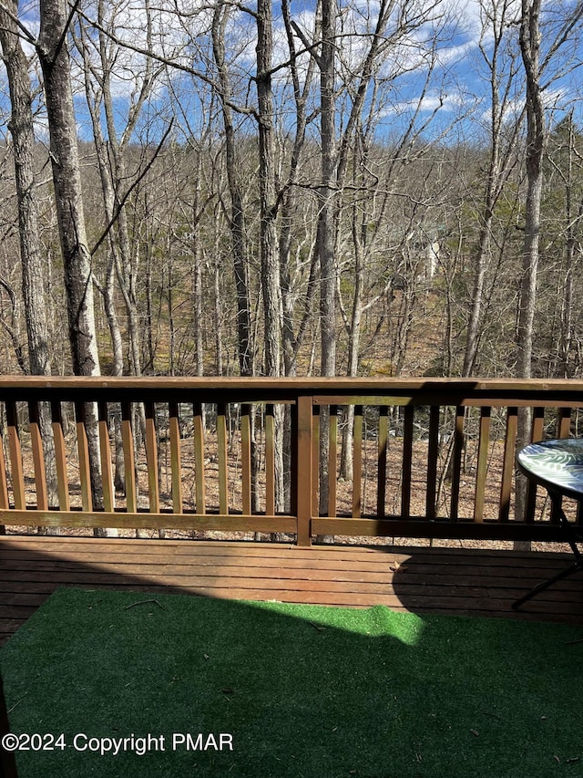 wooden terrace featuring a forest view