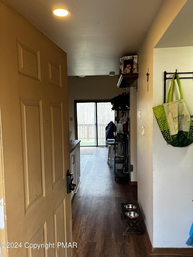 hall featuring dark wood-type flooring and baseboards