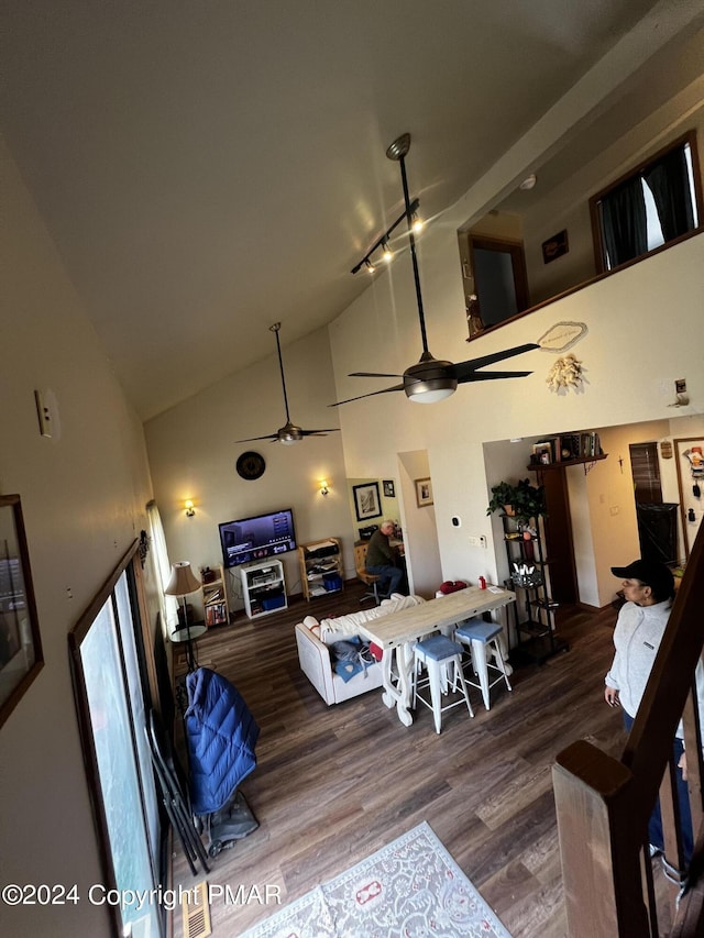 living area featuring rail lighting, ceiling fan, high vaulted ceiling, and wood finished floors