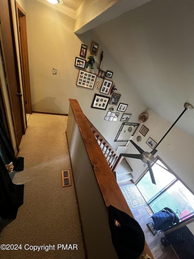 corridor with light carpet, visible vents, and an upstairs landing