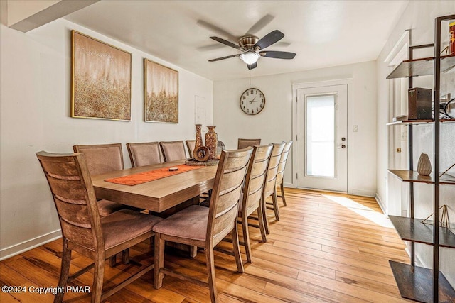 dining room featuring a ceiling fan, light wood-type flooring, and baseboards