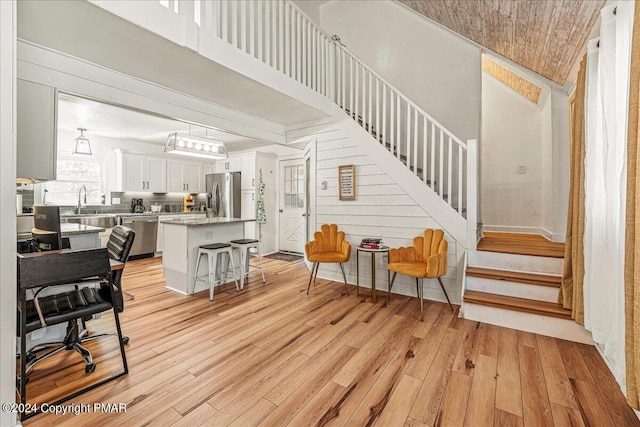 interior space with a high ceiling, stairway, and light wood-style flooring