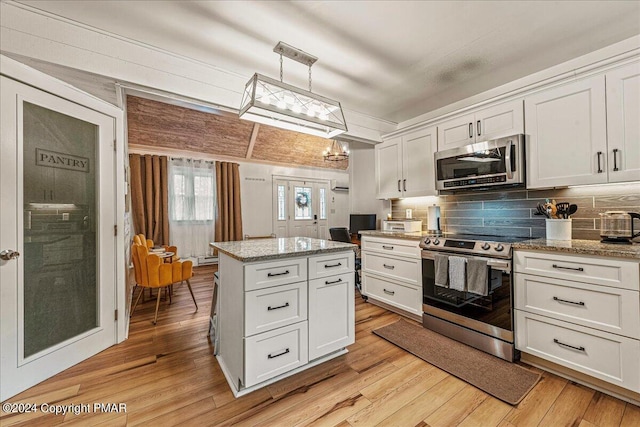 kitchen featuring light wood finished floors, appliances with stainless steel finishes, a kitchen island, and white cabinets