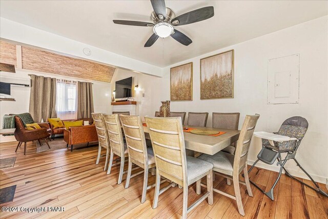 dining area with lofted ceiling, light wood-style floors, and a ceiling fan