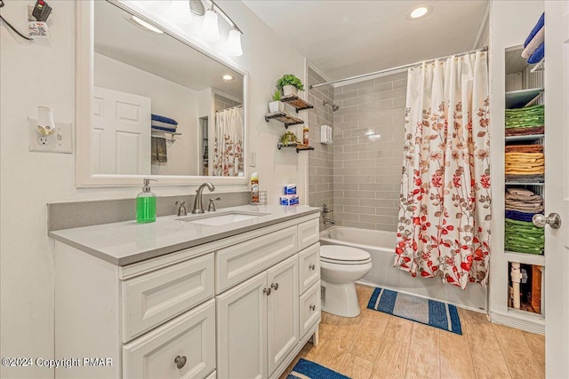 bathroom with shower / bath combo, toilet, wood finished floors, vanity, and recessed lighting