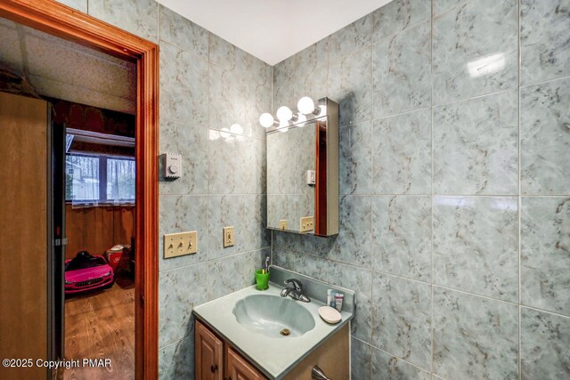 bathroom featuring vanity and tile walls