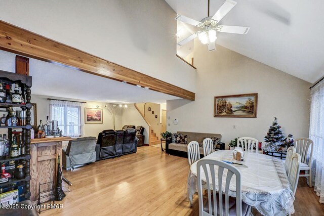 dining room featuring wood-type flooring, high vaulted ceiling, ceiling fan, and beam ceiling