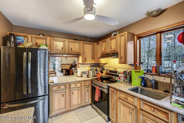 kitchen with appliances with stainless steel finishes, sink, decorative backsplash, ceiling fan, and light stone counters