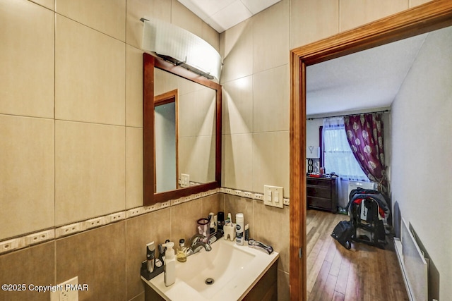 bathroom with tile walls, vanity, backsplash, and hardwood / wood-style floors