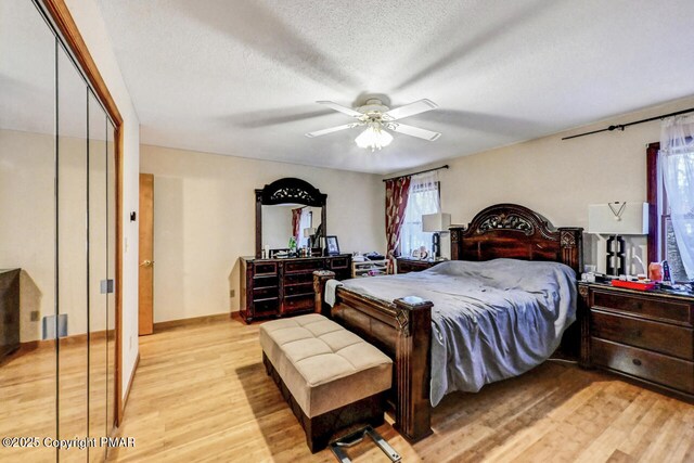 bedroom featuring ceiling fan, a textured ceiling, and light wood-type flooring