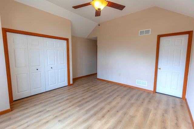 unfurnished bedroom with light wood-type flooring, visible vents, lofted ceiling, and baseboards