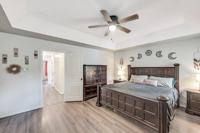 5117 Hounds Ear Rd, Tobyhanna, PA 18466 - bedroom featuring a tray ceiling, light wood-style flooring, and a ceiling fan