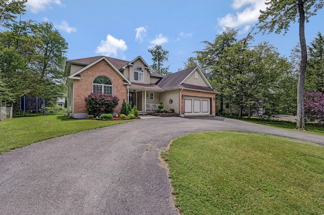 5117 Hounds Ear Rd, Tobyhanna, PA 18466 - view of front of home featuring driveway, a trampoline, brick siding, an attached garage, and a front yard