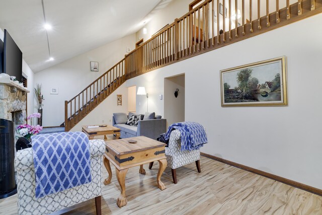 203 Wyomissing Dr, Pocono Lake, PA 18347 - living room featuring stairway, high vaulted ceiling, wood finished floors, a fireplace, and baseboards