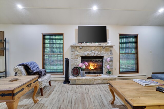 203 Wyomissing Dr, Pocono Lake, PA 18347 - living room with light wood-style floors, a baseboard radiator, and a stone fireplace