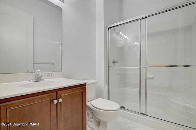 bathroom with an enclosed shower, vanity, tile patterned floors, and toilet