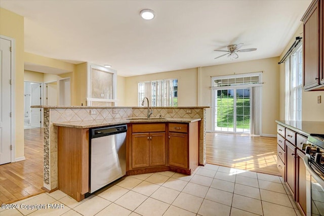 kitchen featuring appliances with stainless steel finishes, sink, decorative backsplash, and light tile patterned floors