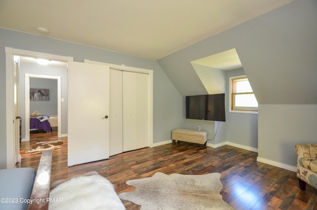 bedroom with lofted ceiling, wood finished floors, and baseboards