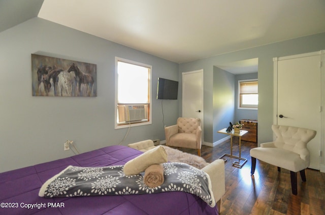 bedroom with cooling unit, baseboards, and wood finished floors