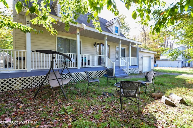 back of house featuring an attached garage and covered porch