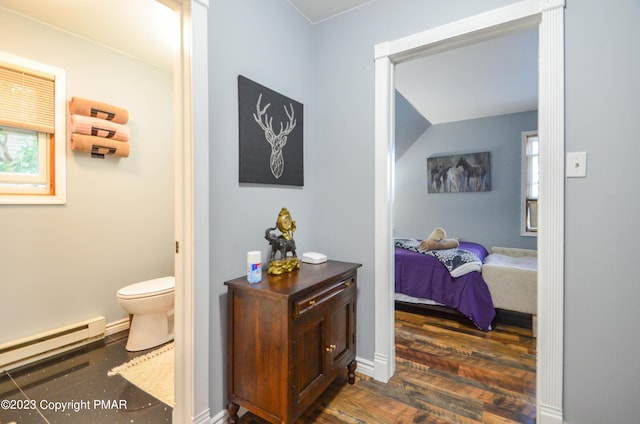 ensuite bathroom featuring baseboards, toilet, a baseboard radiator, wood finished floors, and ensuite bathroom