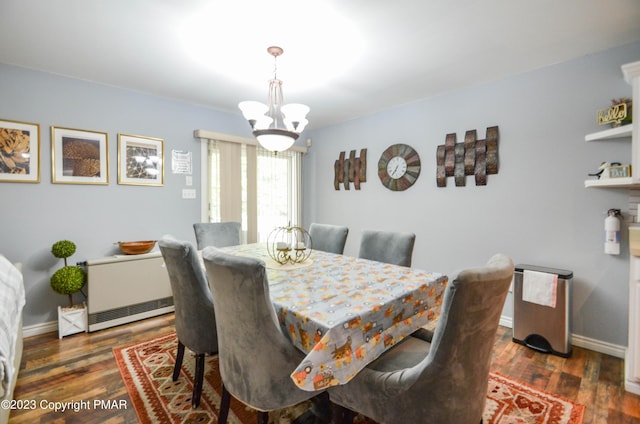 dining room featuring baseboards, a chandelier, and wood finished floors