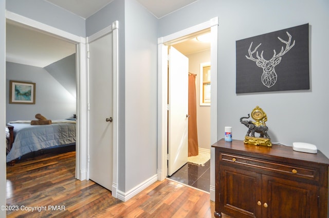 hall featuring baseboards and wood finished floors