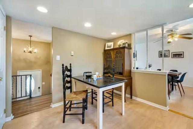 dining area with recessed lighting, baseboards, ceiling fan with notable chandelier, and light wood-style floors