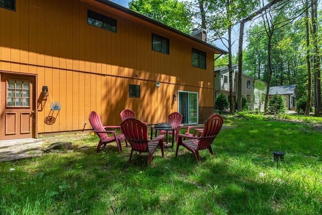 back of property featuring a lawn and a chimney