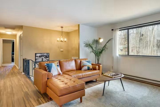 living area featuring a baseboard radiator, wood finished floors, and a chandelier