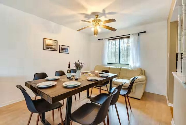dining room featuring baseboards, ceiling fan, and light wood-style flooring