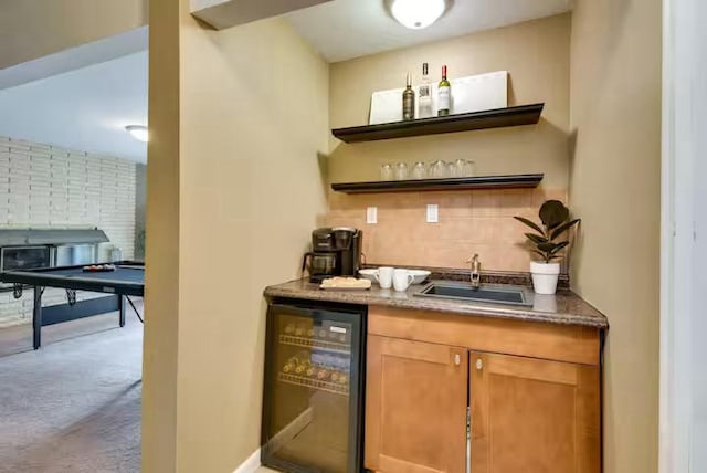 bar featuring decorative backsplash, wine cooler, carpet flooring, indoor wet bar, and a sink