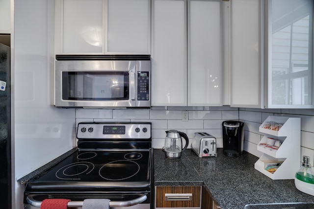 7042 Vista Dr, Tobyhanna, PA 18466 - kitchen with stainless steel appliances, white cabinets, tasteful backsplash, and dark countertops
