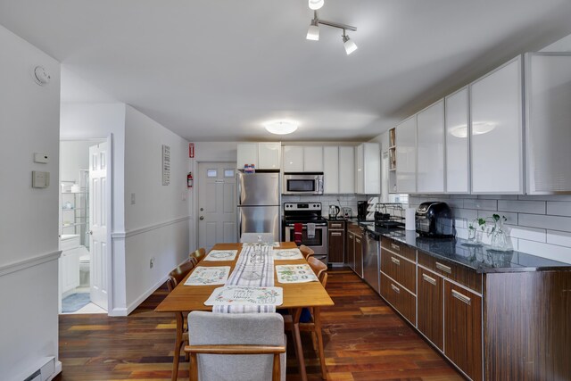 7042 Vista Dr, Tobyhanna, PA 18466 - kitchen featuring appliances with stainless steel finishes, baseboard heating, decorative backsplash, white cabinetry, and dark wood finished floors