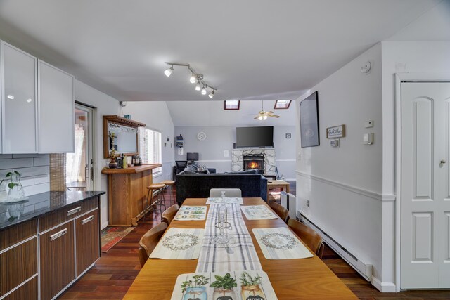 7042 Vista Dr, Tobyhanna, PA 18466 - dining room with a fireplace, a baseboard heating unit, a ceiling fan, and dark wood finished floors