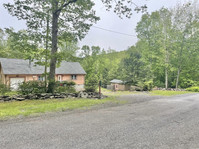 233 Vista Rd, Cresco, PA 18326 - view of front of house with a view of trees, stucco siding, and a garage