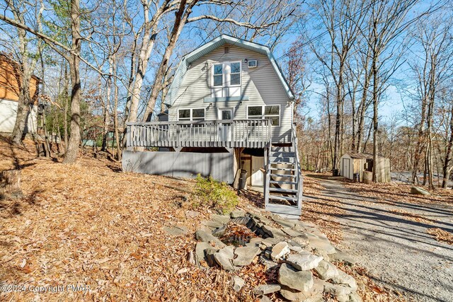 view of front of property with a deck and a storage shed