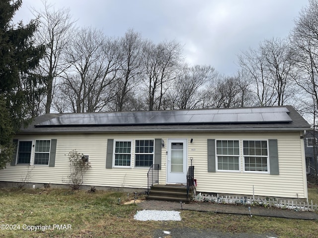 view of front of home featuring entry steps and roof mounted solar panels