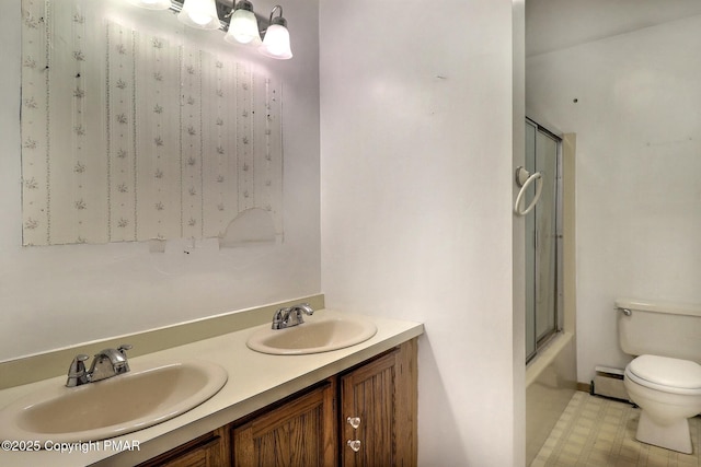 full bathroom featuring vanity, combined bath / shower with glass door, baseboard heating, and toilet