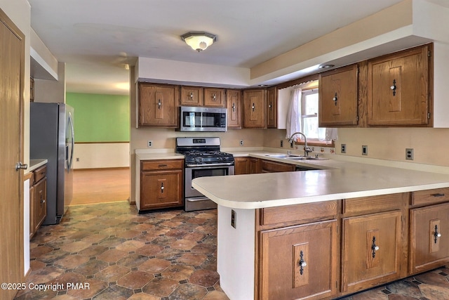 kitchen featuring stainless steel appliances, sink, and kitchen peninsula