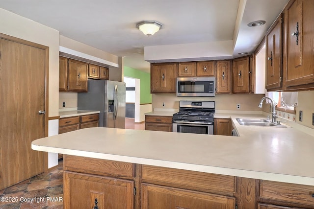 kitchen featuring stainless steel appliances, kitchen peninsula, and sink