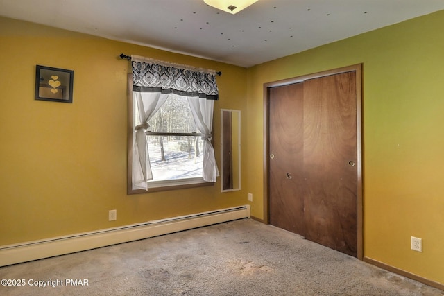 unfurnished bedroom with carpet floors, a baseboard radiator, and a closet