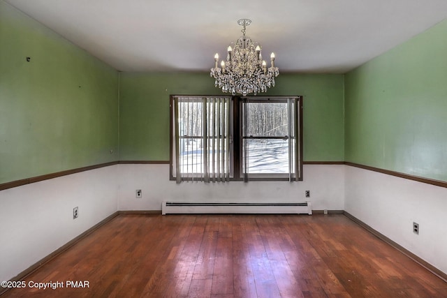 spare room featuring a baseboard radiator, dark hardwood / wood-style floors, and a chandelier