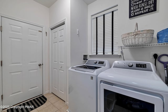 laundry area featuring washer and clothes dryer and light tile patterned floors