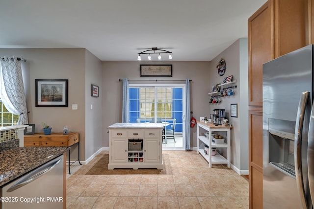 kitchen featuring light tile patterned flooring, rail lighting, dark stone countertops, stainless steel appliances, and white cabinets