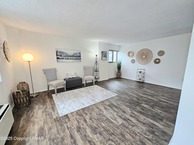 sitting room with a textured ceiling and dark hardwood / wood-style flooring