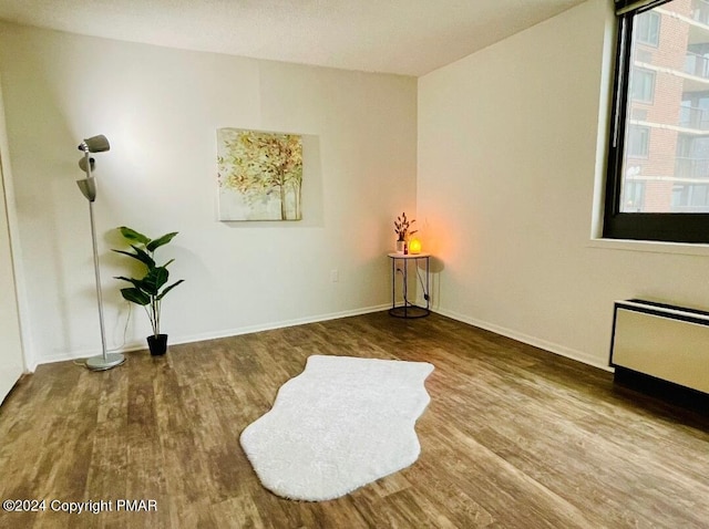 living area featuring radiator, baseboards, and wood finished floors