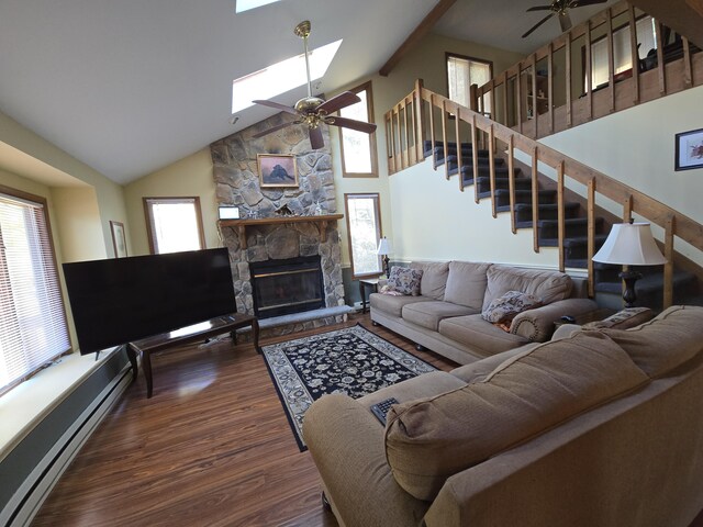 living room with a skylight, plenty of natural light, baseboard heating, and a ceiling fan