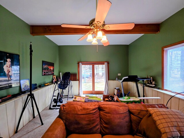 living room with carpet floors, beamed ceiling, and wainscoting